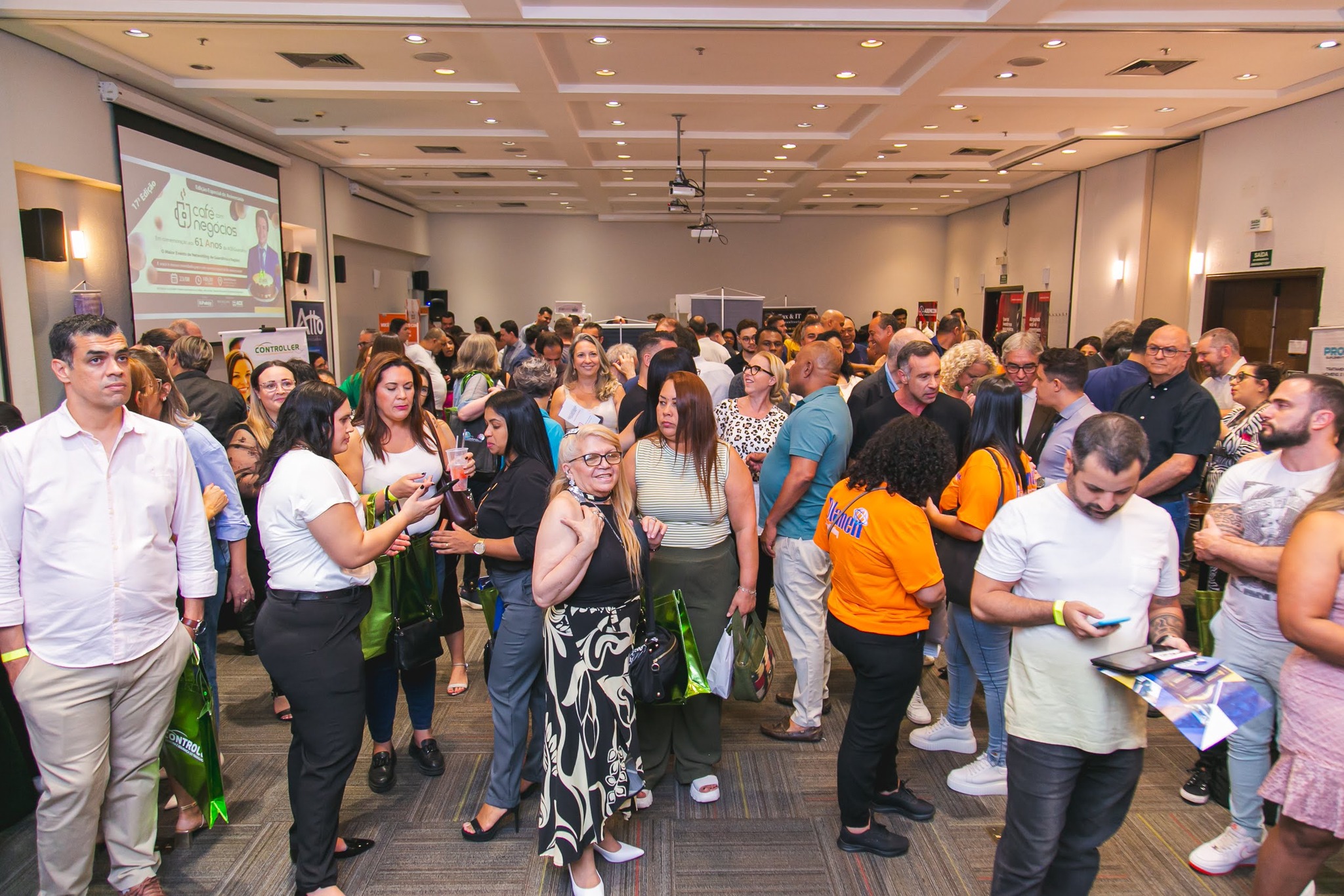 Salão lotado com participantes em networking ativo